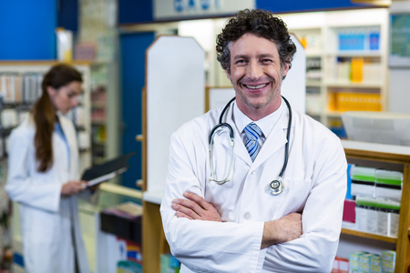 Portrait of pharmacist standing with arms crossed in pharmacyの写真素材