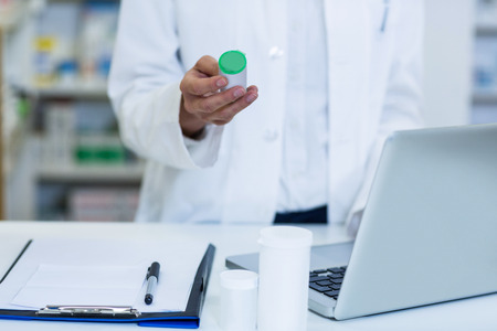 Portrait of pharmacist standing at counter in pharmacyの写真素材
