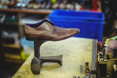 Leather shoe on shoe repair stand in workshopの写真素材