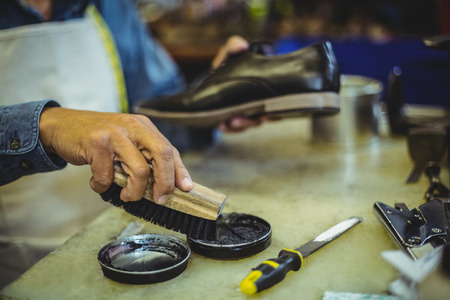 Shoemaker polishing a shoe in workshop