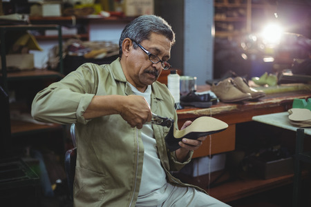 Shoemaker repairing a high heel in workshopの写真素材