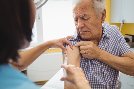 Female doctor giving an injection to a patient at the hospitalの写真素材