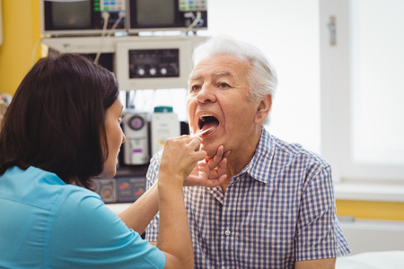 Doctor examining a patient at the hospitalの写真素材