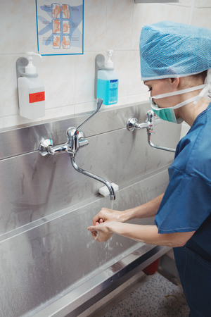Female surgeon washing her hands at the hospitalの写真素材