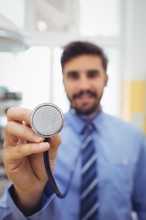Portrait of smiling doctor holding stethoscope at the hospitalの写真素材