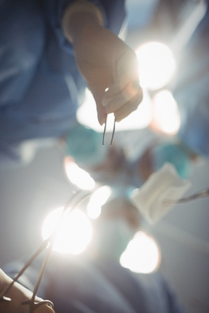 Surgeons performing operation in operation room at the hospitalの写真素材