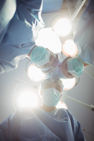 Surgeons performing operation in operation room at the hospitalの写真素材