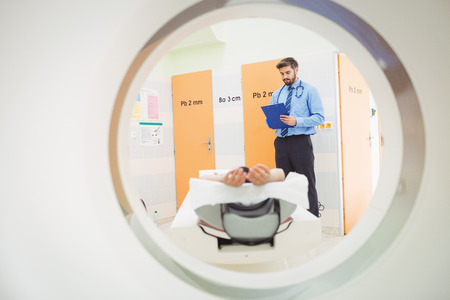 Doctor reviewing chart of patient about to have mri scan at the hospital