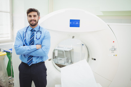 Portrait of doctor standing near mri scanner at the hospitalの写真素材