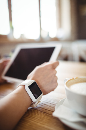 Hands of woman using digital tablet in bakery shopの写真素材