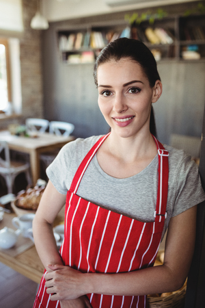 Portrait of female baker smiling in bakery shopの写真素材
