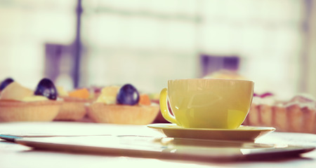 Cup of coffee and tablet pc against pies on a wooden tableの写真素材