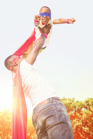 Happy family enjoying together against sun rise over treesの写真素材