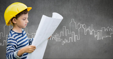 Boy in hard hat reading a plan against hand drawn city plan
