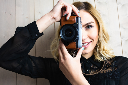 Beautiful woman clicking photo from camera against texture background