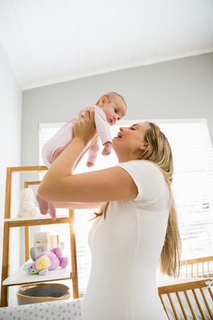 Mother playing with her baby at homeの写真素材