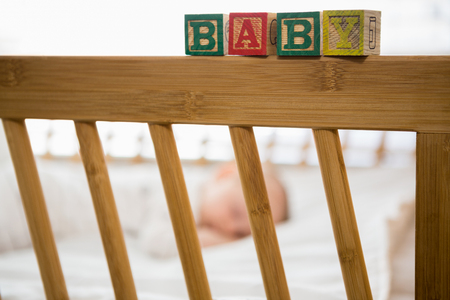 Alphabet blocks on baby bed at homeの写真素材