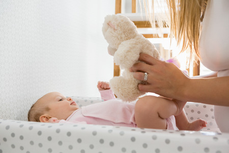 Mother playing with her baby at home