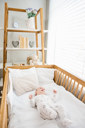 Baby boy relaxing on a cradle at homeの写真素材