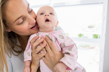 Mother holding her baby boy at homeの写真素材