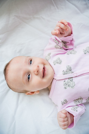 Cute baby boy relaxing on bed at homeの写真素材