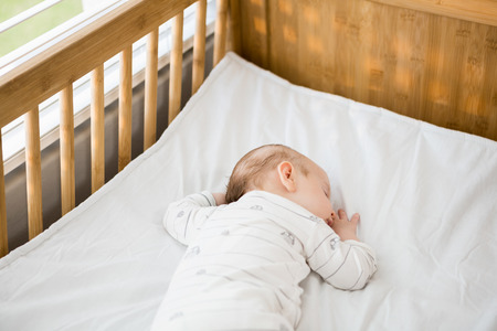 Baby boy sleeping on a cradle at home