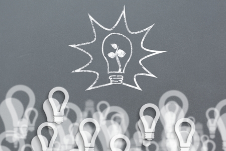 composite of light bulb plant graphic over light bulb backgroundの写真素材