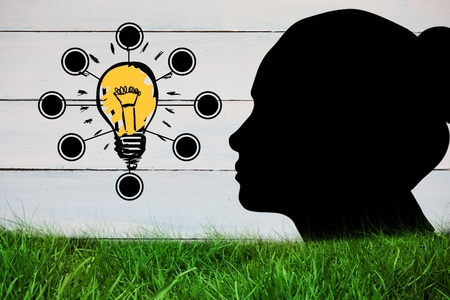 Composite image of woman silhouette with graphic light bulbの写真素材