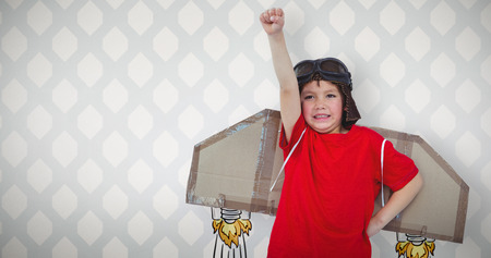 Boy pretending to be a pilot against room with wooden floorの写真素材
