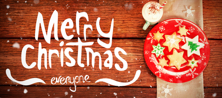 Merry Christmas message against sweet food and cappuccino on wooden tableの写真素材