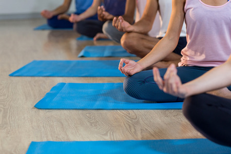 Group of people performing yoga in gymの写真素材