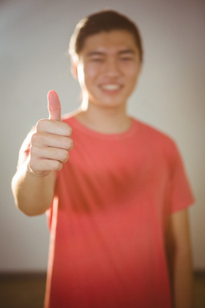 Close-up of man showing thumbs up in gymの写真素材