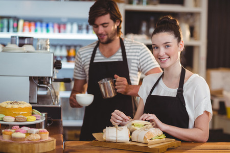 Waiter and waitress working behind the counter in cafeの写真素材