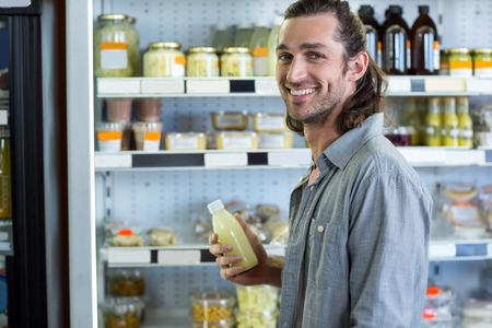 Portrait of happy man shopping for groceries in supermarketの写真素材
