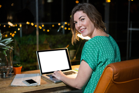 Portrait of businesswoman working on laptop in the officeの写真素材