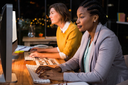 Businesswomen working on computer at their desk in the officeの写真素材