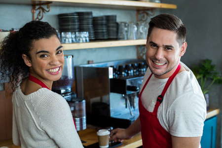 Portrait of smiling waitress and waiter in cafe