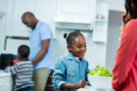 Girl smiling while preparing food in kitchenの写真素材