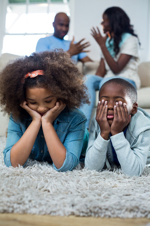 Upset children with parents arguing with each other at homeの写真素材