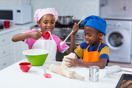 Children preparing cake in kitchenの写真素材