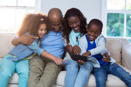 Family using mobile phone at homeの写真素材