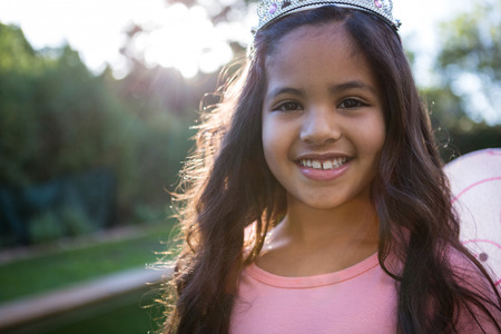 Portrait of happy girl in tiara at the gardenの写真素材