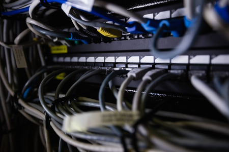 Close-up of ethernet connected in socket at server roomの写真素材