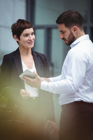 Businesspeople using digital tablet in office premisesの写真素材