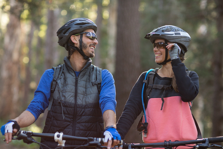 Biker couple smiling and looking at each other in countryside