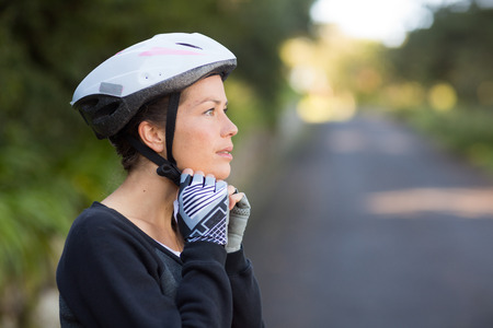 Female biker wearing bicycle helmet in forestの写真素材