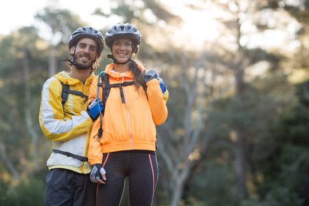 Portrait of biker couple standing in countryside forestの写真素材