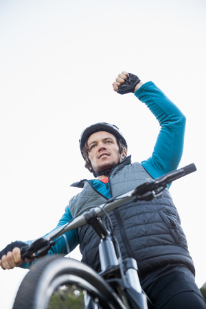 Excited male mountain biker in the forest on a sunny dayの写真素材