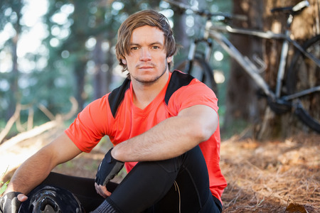 Portrait of male mountain biker in the forest on a sunny dayの写真素材