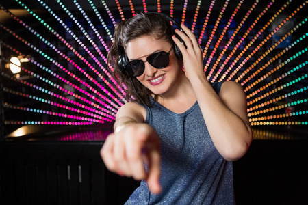 Pretty female DJ playing music at nightclubの写真素材